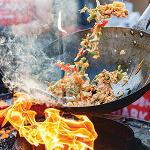 a person stir-frying a wok full of vegatables